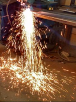 A person is using an angle grinder to cut metal.