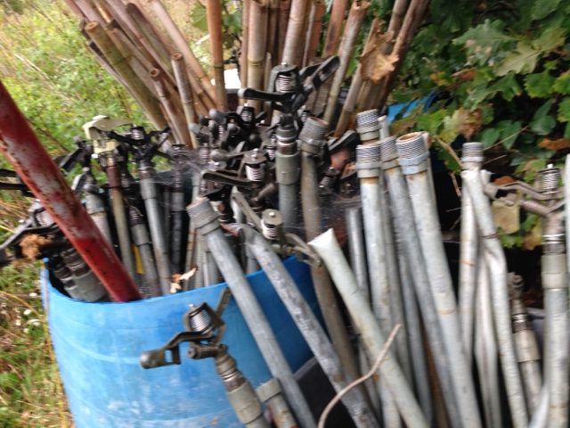 A bunch of pipes are stacked together in the yard