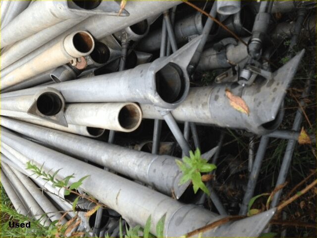 A pile of pipes sitting in the grass.