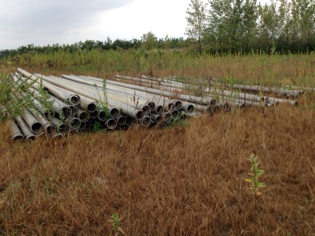 A pile of pipes sitting in the grass.